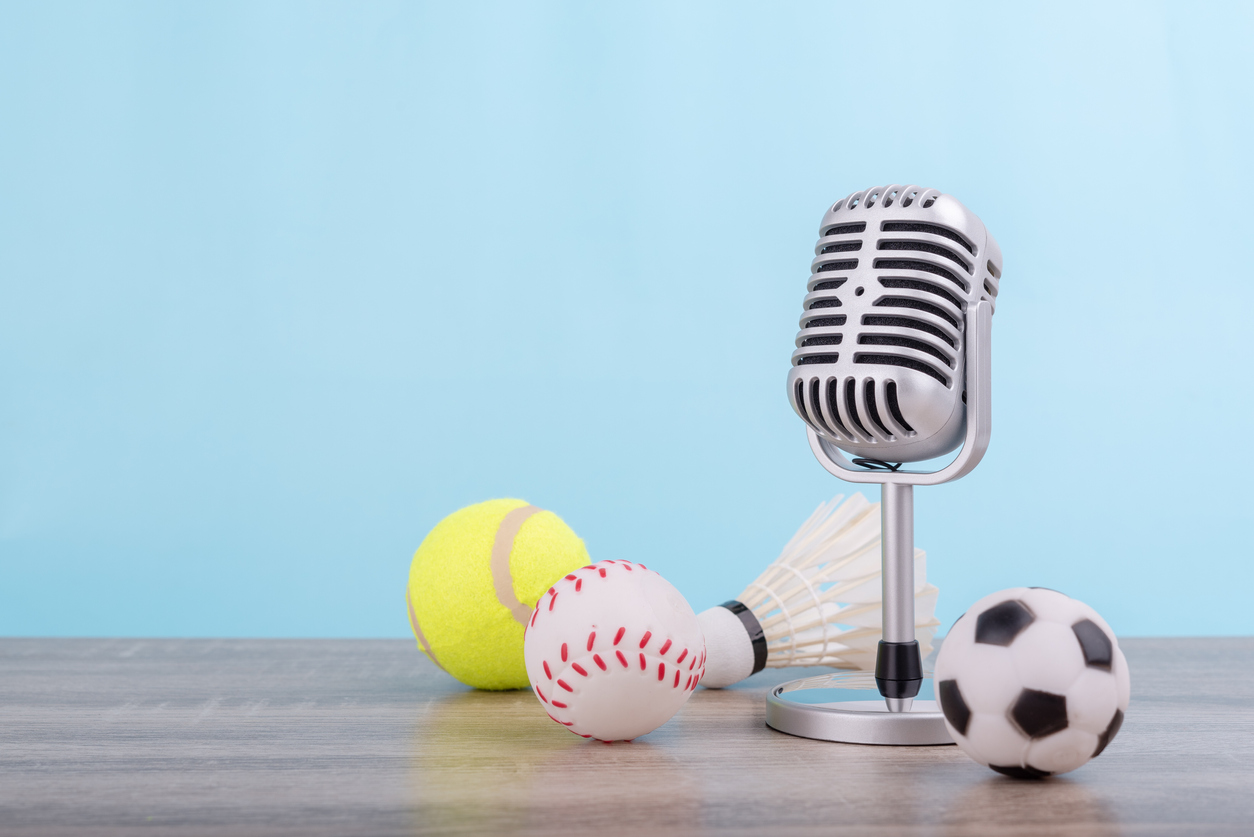Soccer ball, baseball, and tennis ball next to a microphone.