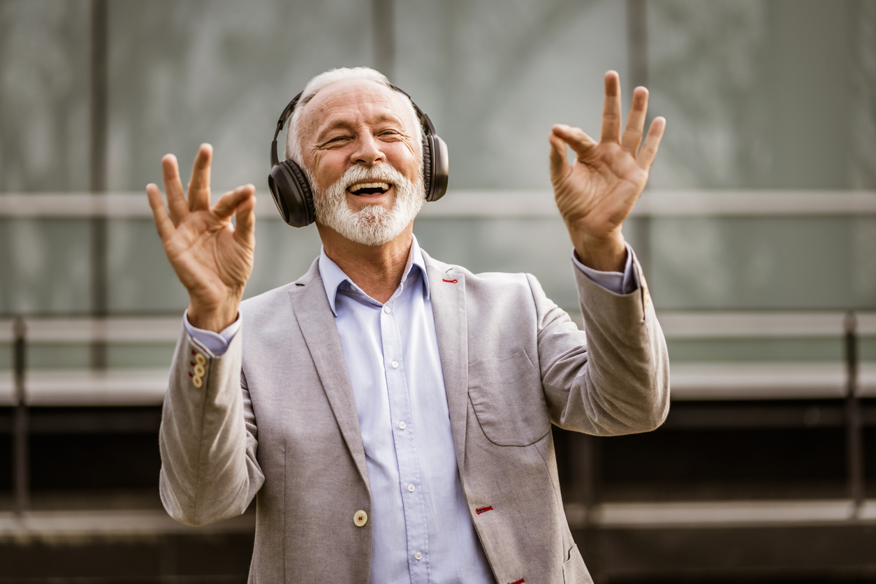 Senior man enjoying music on headphones.